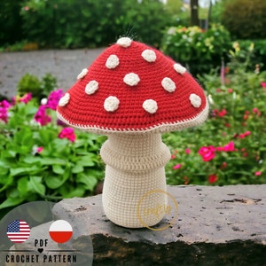 May include: Crochet pattern for a red and white mushroom amigurumi. The mushroom has a white stem and a red cap with white polka dots. The pattern is available in PDF format.
