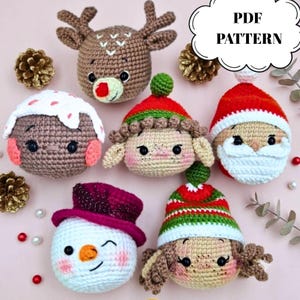 May include: A collection of six crocheted Christmas ornaments featuring a reindeer, a pudding, an elf, Santa Claus, a winking snowman with a purple hat, and a character in a striped hat. The image includes the text PDF PATTERN in a speech bubble.