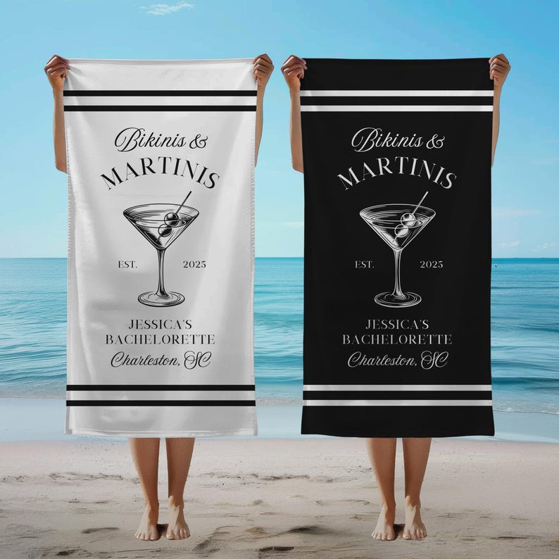 May include: Two white beach towels with black stripes. The towels feature a martini glass with olives, the text "Bikinis & Martinis", and the text "Jessica's Bachelorette Charleston, SC".
