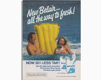 May include: A vintage advertisement for Belair cigarettes featuring a couple on a yellow inflatable raft in the sea. The text reads "New Belair... all the way to fresh!" and "NOW 30% LESS 'TAR'!" with the tagline "Just the right touch of menthol. Never heavy. Never harsh. The taste is pure fresh!" The ad also states "Now only 9 mg!"