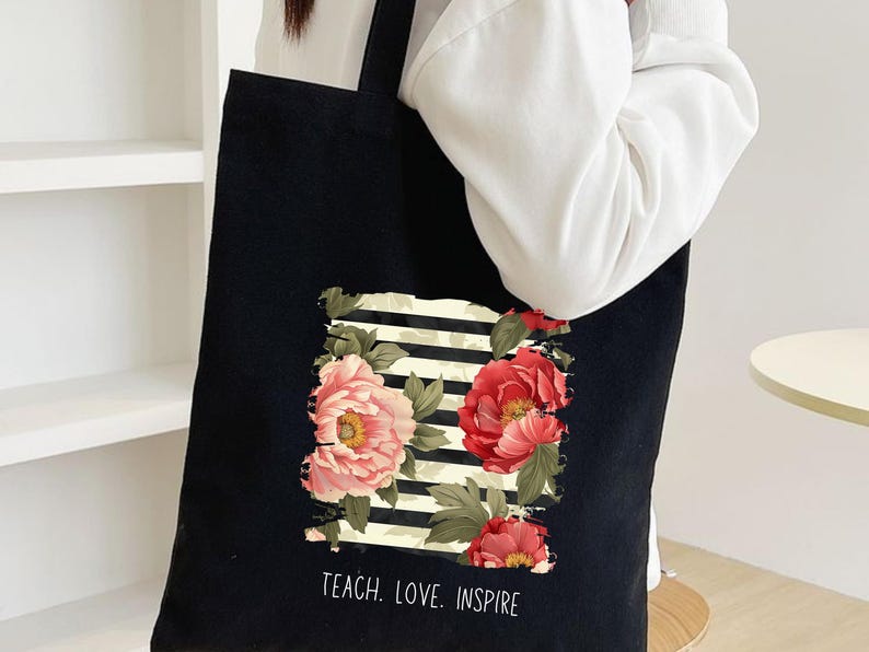 Puede incluir: Una taza de cer&aacute;mica blanca con asa negra y el texto "But First, Coffee" en negrita negra. La taza se encuentra sobre un fondo borroso, sugiriendo un ambiente acogedor.