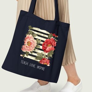 Puede incluir: Una taza de cer&aacute;mica blanca con un asa negra y el texto "But First, Coffee" en negrita negra. La taza se encuentra sobre un fondo neutro, resaltando su dise&ntilde;o simple.