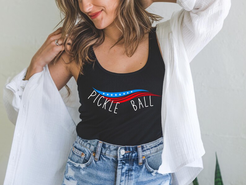 May include: A black tank top with a red, white, and blue wave design and the text "Pickle Ball" in white.