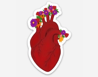 以下が含まれることがあります： 赤い解剖学的心臓に、紫、ピンク、オレンジの花が咲いています。