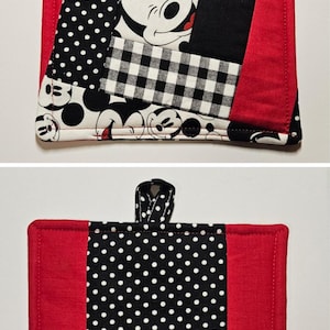 May include: Two red and black pot holders. One pot holder has a patchwork design with Mickey Mouse faces and polka dots. The other pot holder has a black and white polka dot design with red borders.