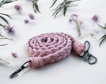 May include: A pink braided lanyard with a silver swivel clip and a black metal lobster clasp.