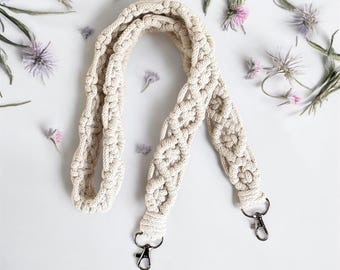 May include: A white crocheted camera strap with two silver swivel clips.