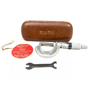 May include: A silver micrometer with a black and blue handle, a red tag with the text "IMPORTANT This is a M&W Precision Instrument Treat it as such Read the other side carefully", a brown leather case with the text "MOORE & WRIGHT, (SHEFFIELD) LTD. ENG.", and a wrench.