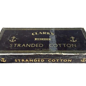 May include: A black box with gold lettering that reads "Clark's Anchor Stranded Cotton Fast Colors" and a smaller label on the bottom that reads "Stranded Cotton".