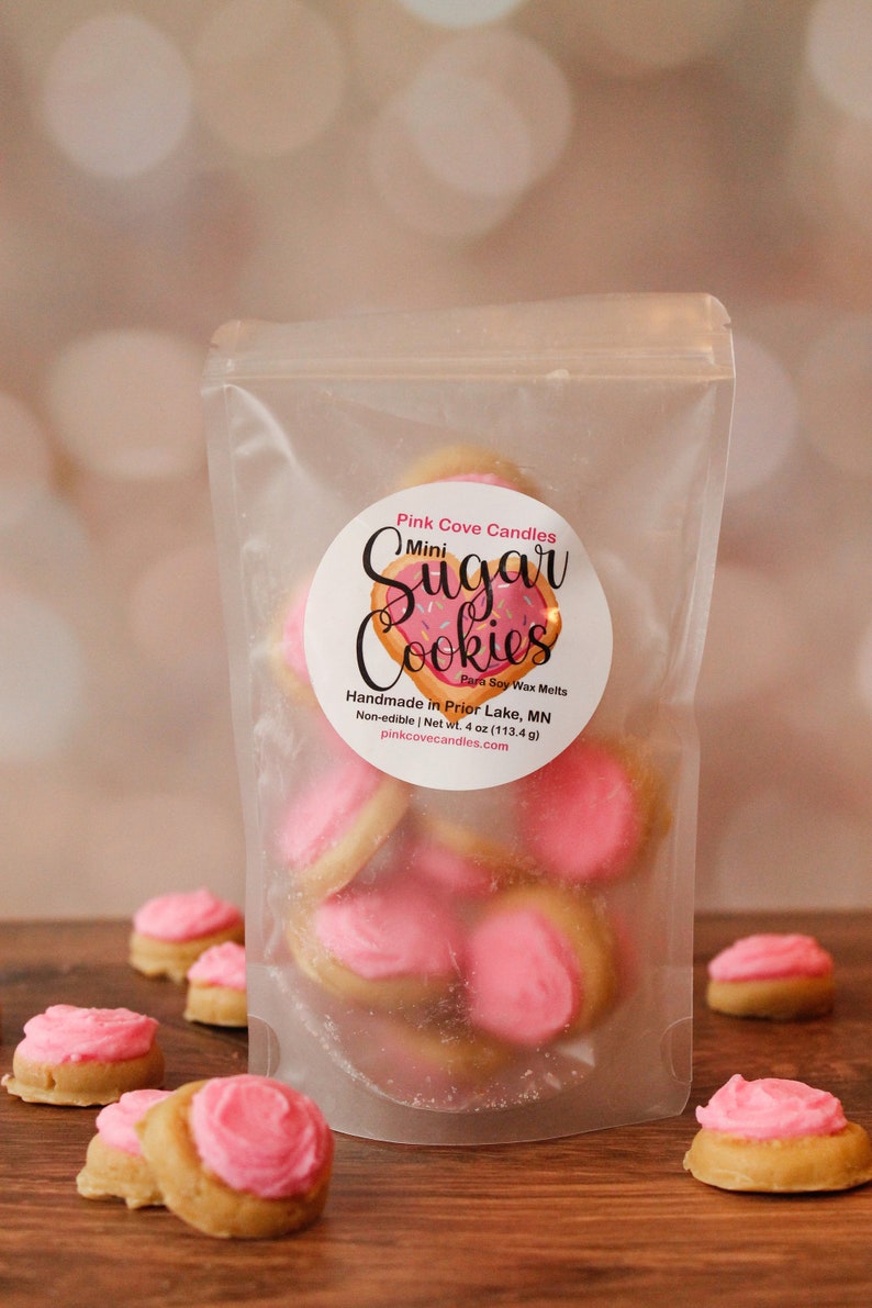 K&ouml;nnte beinhalten: Eine transparente Plastikt&uuml;te gef&uuml;llt mit rosa und wei&szlig;en Mini-Zuckerkeks-Duftwachs-Schmelzen. Die T&uuml;te hat ein Etikett mit der Aufschrift "Pink Cove Candles Mini Sugar Cookies Para Soy Wax Melts Handmade in Prior Lake, MN Non-edible | Net wt. 4 oz (113.4 g) pinkcovecandles.com".