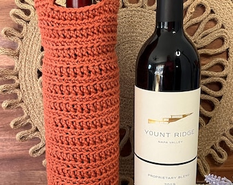 May include: A crocheted orange wine bottle cosy with a bottle of Yount Ridge Proprietary Blend Napa Valley wine from 2019.