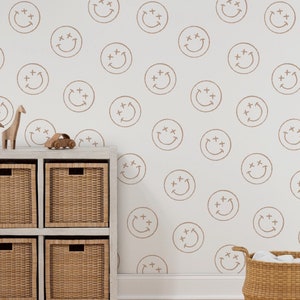 May include: A white wall with a brown smiley face pattern. A white shelf unit with brown wicker baskets is in front of the wall. A toy car and wooden animal figurines are on top of the shelf.