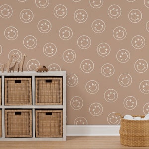 May include: A brown wall with a white smiley face pattern. A white shelf unit with brown wicker baskets is in front of the wall. There are wooden toy animals on the shelf.