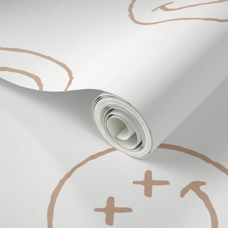 May include: A roll of white wallpaper with a repeating pattern of brown smiley faces. The smiley faces have a simple design with two eyes, a nose, and a mouth.