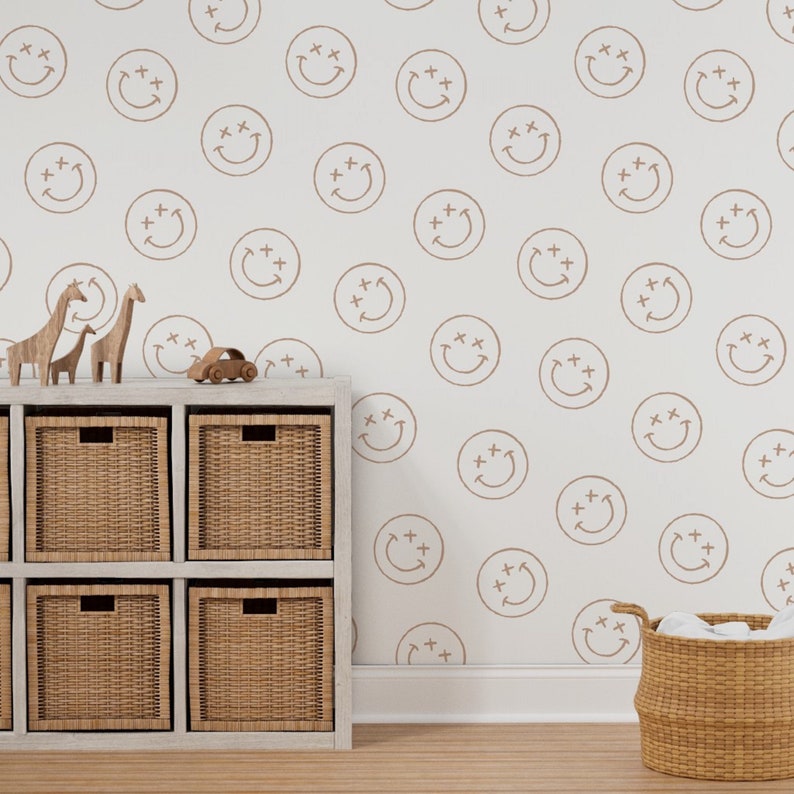 May include: A white wall with a brown smiley face pattern. A white shelf unit with brown wicker baskets is in front of the wall. A toy car and wooden animal figurines are on top of the shelf.
