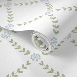 May include: A roll of white wallpaper with a repeating pattern of blue flowers and green leaves.