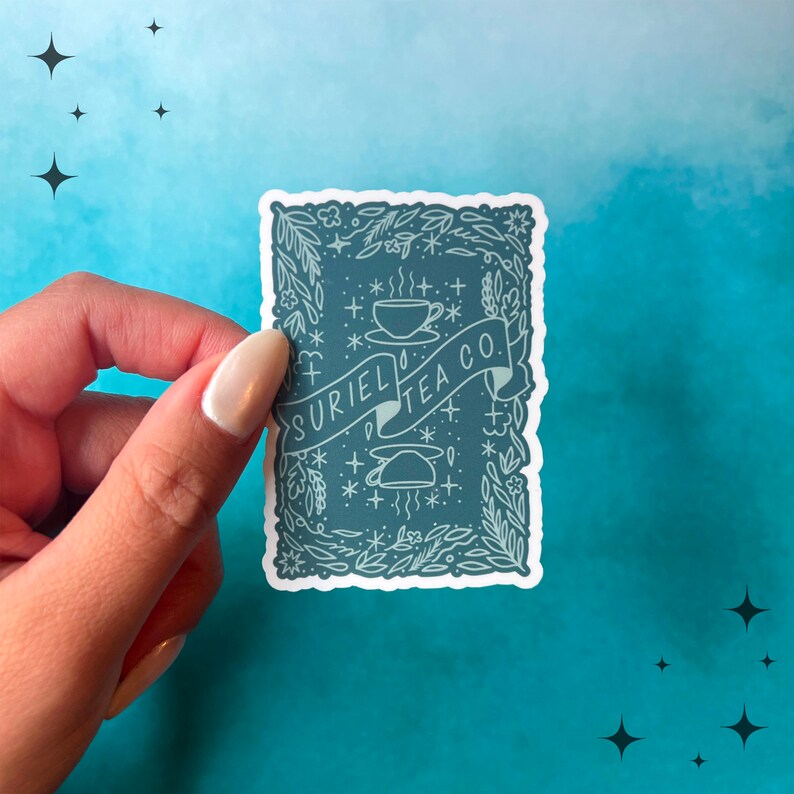 May include: A teal sticker with the text "SURIEL TEA CO." in a banner. The sticker features a teacup, teapot, and floral elements. The background is a gradient of teal and blue with star shapes.