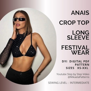Peut inclure: Haut court noir avec une manche longue et des détails scintillants. Le haut est conçu pour les festivals. Le texte sur l'image dit "ANAIS CROP TOP LONG SLEEVE FESTIVAL WEAR". Tailles XS-XXL.
