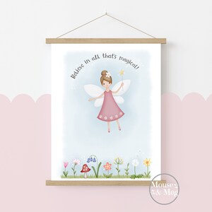 May include: A whimsical illustration of a fairy with pink wings and a pink dress, holding a magic wand. The fairy is flying above a field of flowers and a mushroom. The text "Believe in all that's magical!" is written above the fairy.