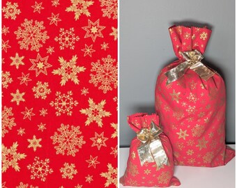 Pochette cadeau de noël Flocons fond rouge en tissu, réutilisable