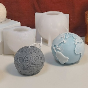 Può includere: Tre diversi stampi per candele, due sono bianchi e uno è grigio. Lo stampo grigio è a forma di luna, gli stampi bianchi sono a forma di sfera e di globo. Lo stampo a forma di globo contiene una candela blu.