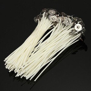 May include: A bundle of white candle wicks with metal tops. The wicks are bundled together and ready to be used for candle making.