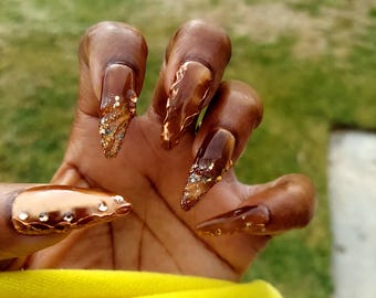 Uñas postizas con purpurina y efecto ojo de gato marrón