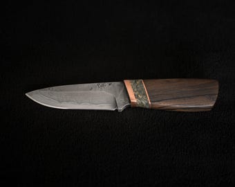 May include: A small, fixed blade knife with a dark wood handle and a copper accent. The blade has a damascus pattern.