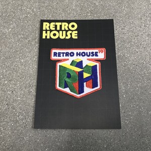 May include: A black card with the text "RETRO HOUSE" in yellow. Below is a patch with the words "RETRO HOUSE" in a red and white rectangle. The patch has a colorful "RH" logo.