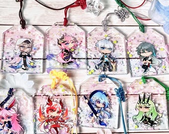 May include: A collection of acrylic charms featuring anime-style characters. Each charm is a rectangular shape with a clear background filled with pink glitter. The characters have various hair colors and outfits, and are attached to decorative cords.