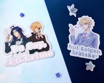 May include: Two illustrated stickers featuring anime characters. The first sticker features two men in suits with the text "Be Gay, Solve Crime". The second sticker features a man in a suit with the text "Not Reigen Arataka~."