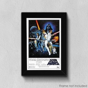 May include: A framed Star Wars movie poster. The poster features a dark blue space scene with characters and the Star Wars logo. The frame is black and the text "Frame not included" is at the bottom.