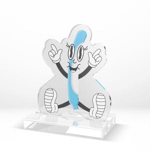 May include: A cartoon-style character with a blue and white design. The character has a smiling face, black arms, and white gloves. It is sitting on a clear, rectangular base. The character's body is light gray with a blue stripe.