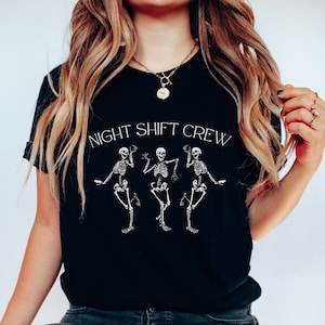 May include: A black t-shirt with a white graphic of three skeletons dancing and the text "NIGHT SHIFT CREW".