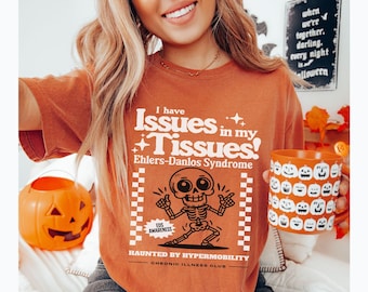 May include: A rust-colored t-shirt with a skeleton graphic and the text "I have Issues in my Tissues! Ehlers-Danlos Syndrome Haunted by Hypermobility Chronic Illness Club".