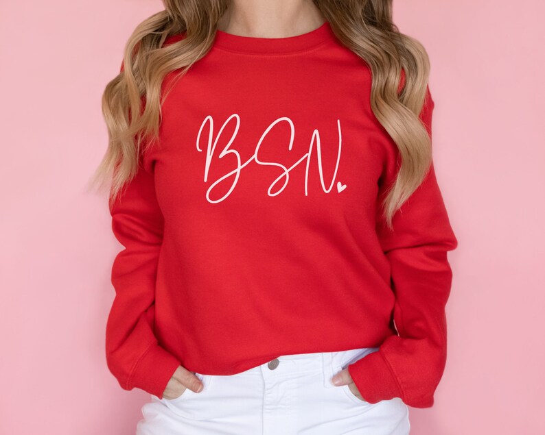 May include: Red sweatshirt with white cursive text that says "BSN" with a small heart after the N.