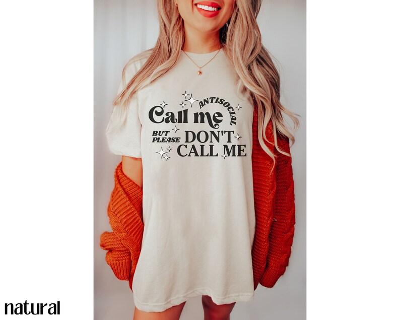 Puede incluir: Una camiseta blanca con el texto "Call me antisocial but please don't call me" en letras negras con estrellas alrededor del texto.