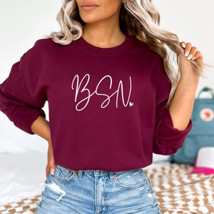 May include: A maroon sweatshirt with the text "BSN" in white script lettering.