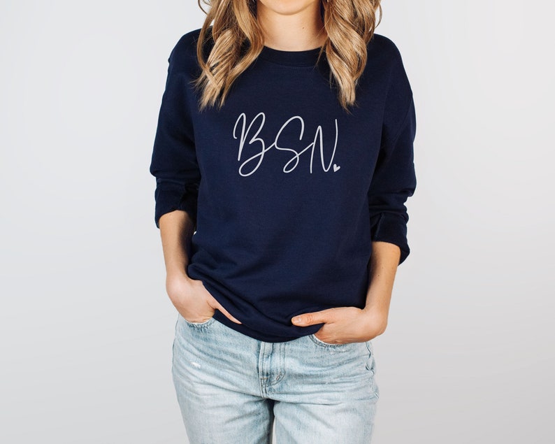 May include: A navy blue sweatshirt with the text "BSN" in white script lettering. The sweatshirt has a crew neck and long sleeves.