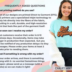 Puede incluir: Una mujer con una camiseta azul claro con las palabras "Sad but Healing" en naranja y marr&oacute;n. El texto est&aacute; en una fuente retro. La camiseta se combina con pantalones cortos negros y un su&eacute;ter blanco. El texto en el lado izquierdo de la imagen dice "PREGUNTAS FRECUENTES".