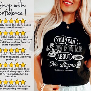 Peut inclure: T-shirt noir avec un graphique d'extraterrestre blanc et le texte "You Can Talk To Me About Drugs No Stigma No Judgement, No Shame."