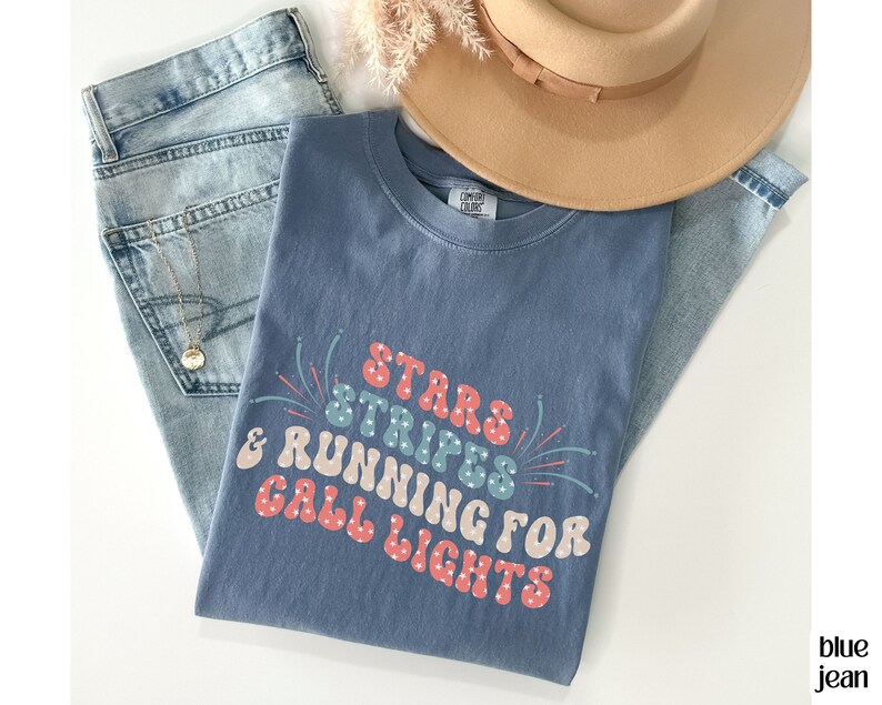 May include: A blue t-shirt with a white, red, and blue graphic that says "Stars & Stripes & Running for Call Lights".
