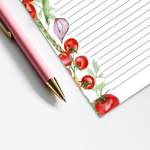 May include: A lined notepad with a watercolor border of tomatoes, onions, and asparagus. The notepad is perfect for jotting down grocery lists, meal plans, or other notes.