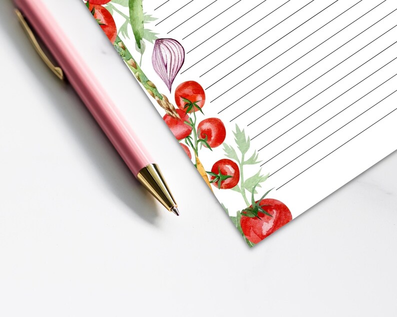 May include: A lined notepad with a watercolor border of tomatoes, onions, and asparagus. The notepad is perfect for jotting down grocery lists, meal plans, or other notes.