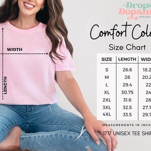 May include: A light pink unisex t-shirt with a size chart and the text "Comfort Colors." The size chart shows measurements in inches for sizes S to 4XL. The shirt is labeled "1717 Unisex Tee Shirt."