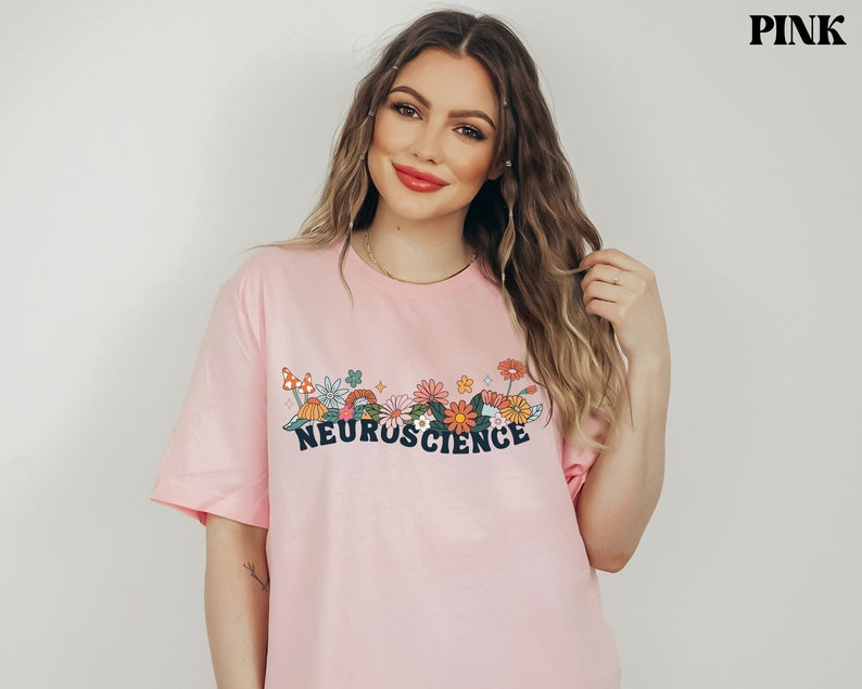 May include: A pink t-shirt with a floral design and the text "NEUROSCIENCE" in black.