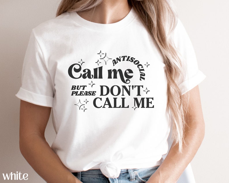 Puede incluir: Camiseta blanca con texto negro que dice "Call me antisocial but please don't call me". El texto est&aacute; rodeado de estrellas.