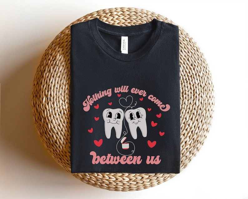 Puede incluir: Camiseta negra con un gr&aacute;fico de dos dientes de dibujos animados con corazones y el texto "Nada se interpondr&aacute; jam&aacute;s entre nosotros".