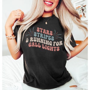 May include: A black t-shirt with a retro-style graphic that says "Stars & Stripes & Running for Call Lights".
