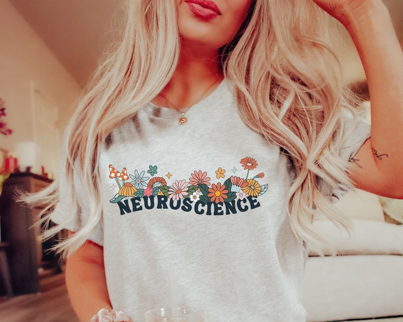 May include: A grey t-shirt with a floral design and the text "NEUROSCIENCE" in black letters.